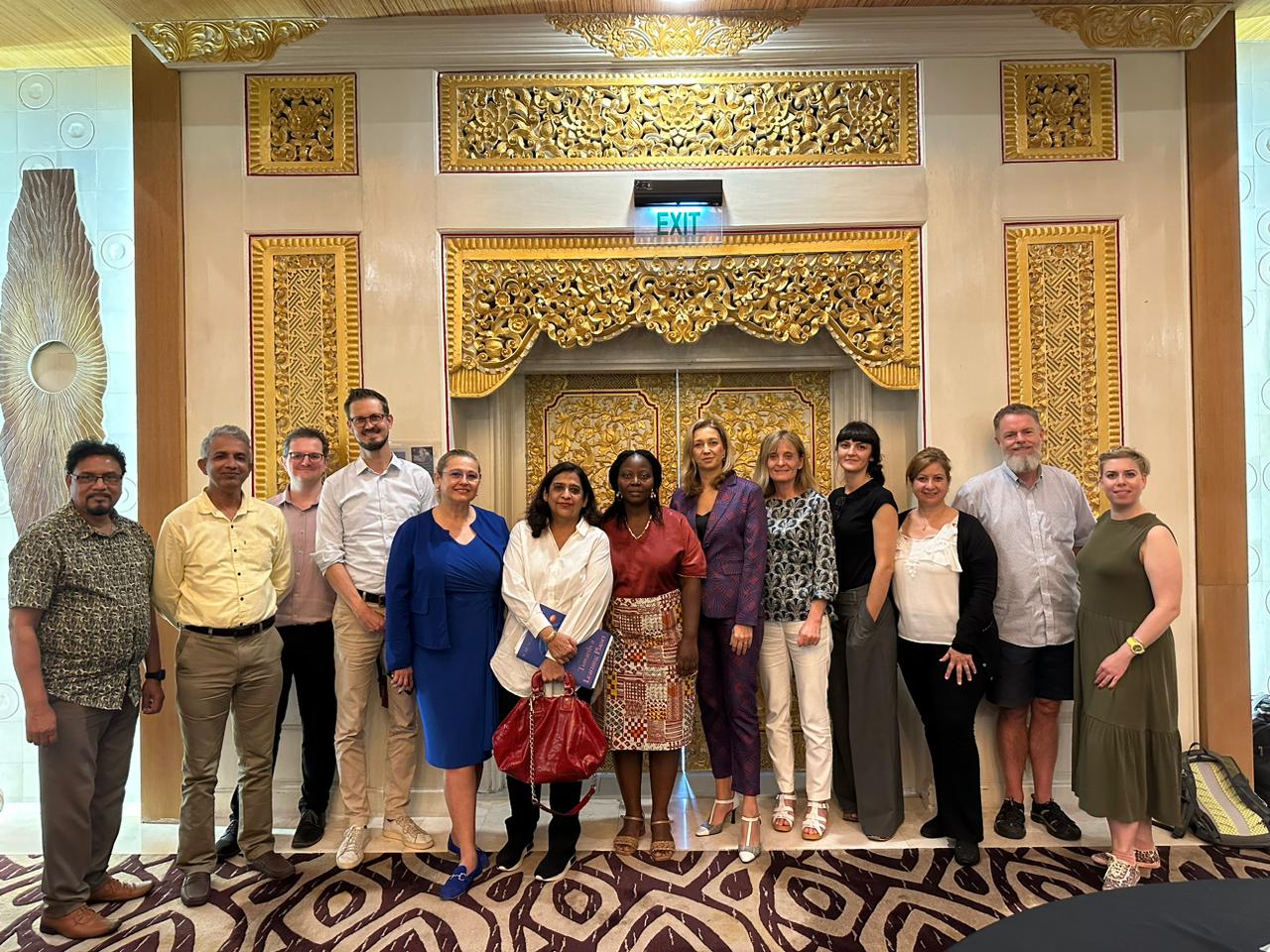 Group of participants at the World Assembly on Adult Education - people from different parts of the world in front of a decorated Balinese door